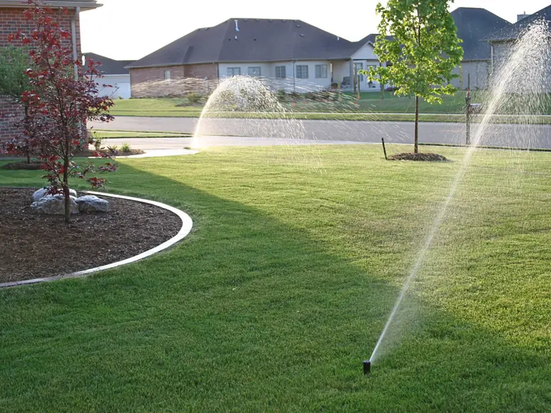 An irrigation system running across a manicured front lawn