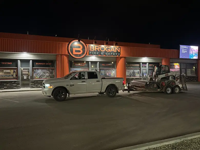 A Foreterra truck and skid steer on a commercial site in the evening