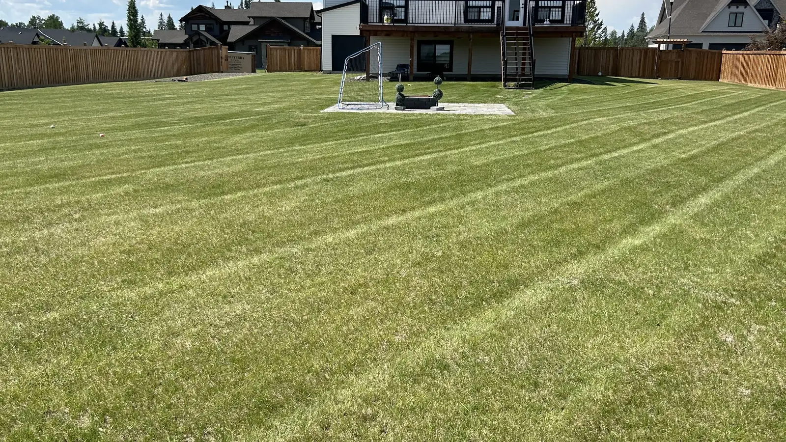 Freshly cut and striped backyard lawn at a Grande Prairie home